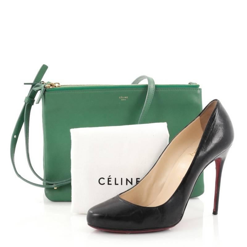 This authentic Celine Trio Crossbody Bag Leather Large is a minimalist crossbody perfect for on-the-go moments. Crafted from green leather, this impossibly chic bag features adjustable shoulder strap, gold-tone snap buttons that easily detaches