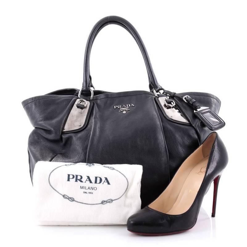 This authentic Prada Buckle Tote Glace Calf Large is the ideal bag for everyday use and light traveling. Constructed in navy glace calf leather, this simple tote features dual-rolled leather handles, raised Prada MIlano logo and accented with