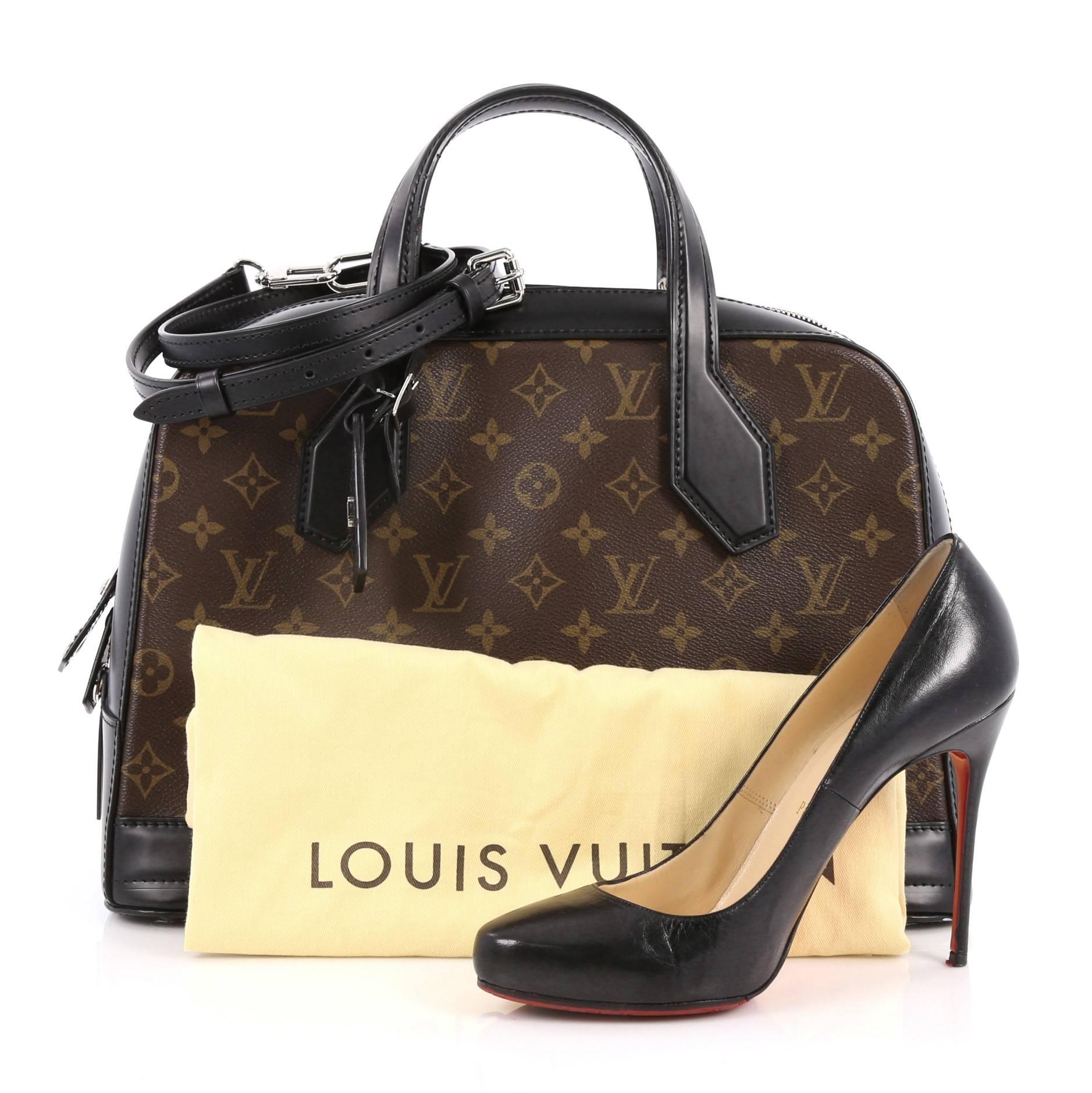 This authentic Louis Vuitton Dora Handbag Monogram Canvas and Calf Leather MM presented in the brand's Pre-Fall 2015 Collection is inspired by Gaston Vuitton's iconic squire travel bag. Crafted from brown monogram coated canvas and black leather,
