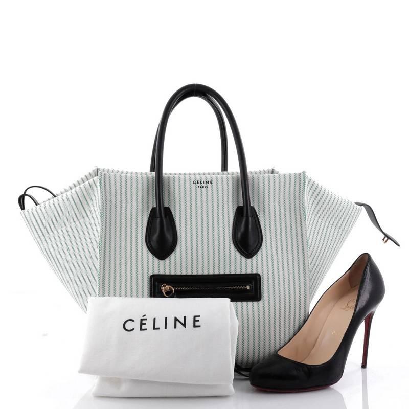 This authentic Celine Phantom Handbag Striped Canvas and Leather Medium is one of the most sought-after bags beloved by many fashionistas. Crafted from green and white striped canvas, this minimalist tote features dual-rolled leather handles, an