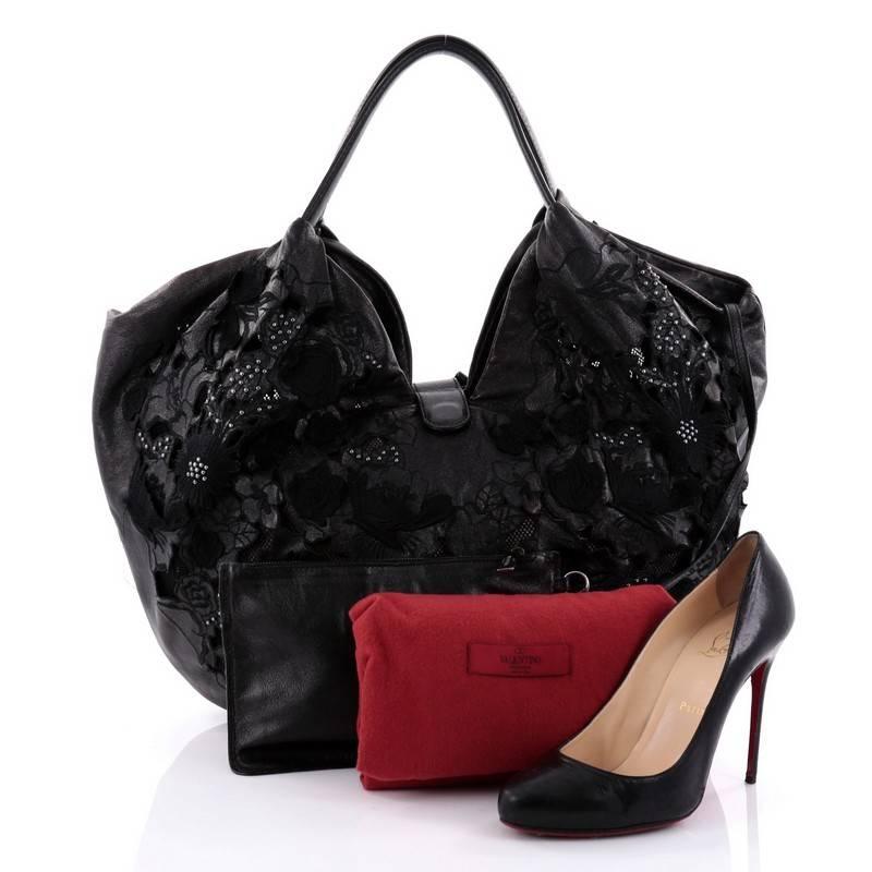 This authentic Valentino 360 Bow Hobo Leather Lace Large is a marvelous hobo for day or evening looks. Crafted from black leather, this stylish bag features dual leather handles, large decorative bow, and silver-tone hardware accents. It opens to a