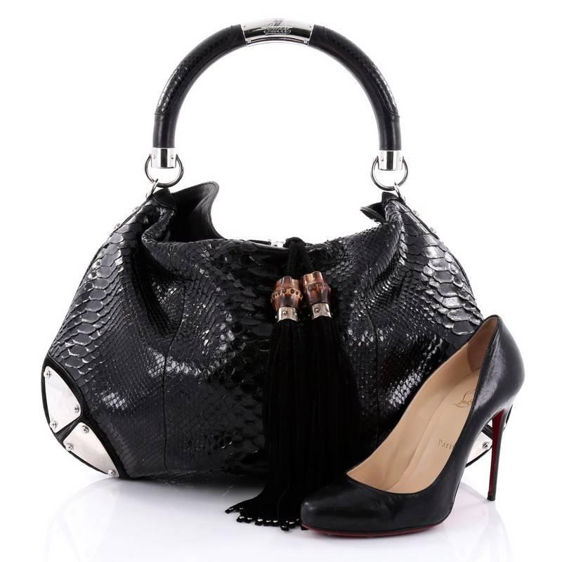 This authentic Gucci Indy Hobo Python Large showcases the brand's classic design with luxurious detailing adding an exotic chic twist. Crafted from genuine black python skin, this eye-catching hobo features bamboo and fringe tassels, looped handle,