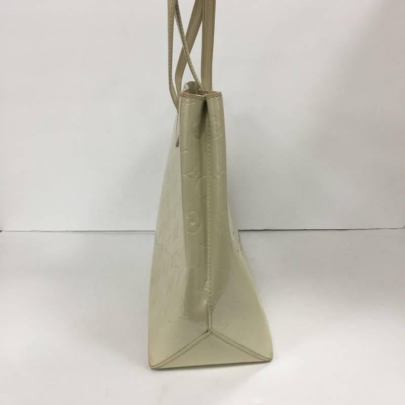 This authentic Louis Vuitton Wilshire Handbag Monogram Vernis MM combines elegance and sophistication ideal for day to day excursions. Crafted in off-white monogram vernis leather, this simple shopper tote features dual-flat handles, a sturdy base