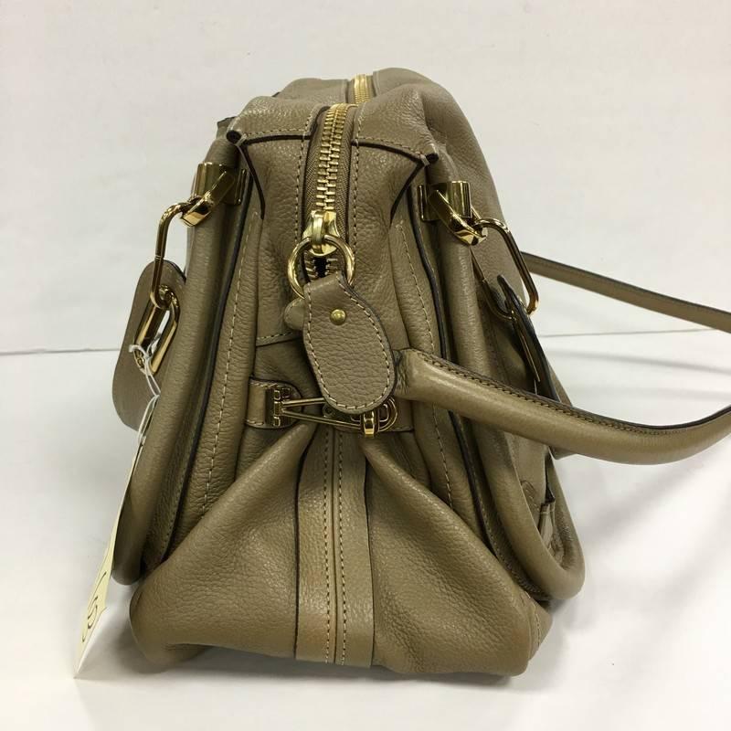 This authentic Chloe Paraty Top Handle Bag Leather Medium mixes everyday style and functionality perfect for the modern woman. Crafted from taupe leather, this versatile bag features dual flat handles, piped trim details, side twist locks, and