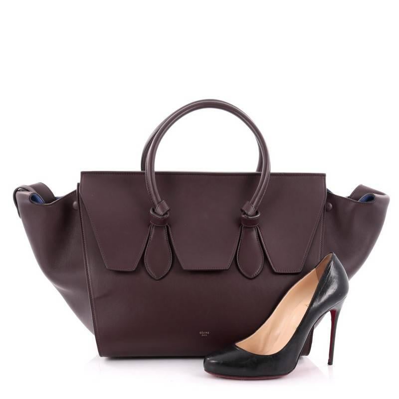 This authentic Celine Tie Knot Tote Smooth Leather Medium presented in the brand's Fall/Winter 2014 Collection is an absolute must-have for serious fashionistas. Crafted from burgundy smooth leather, this boxy, chic tote features dual-rolled leather
