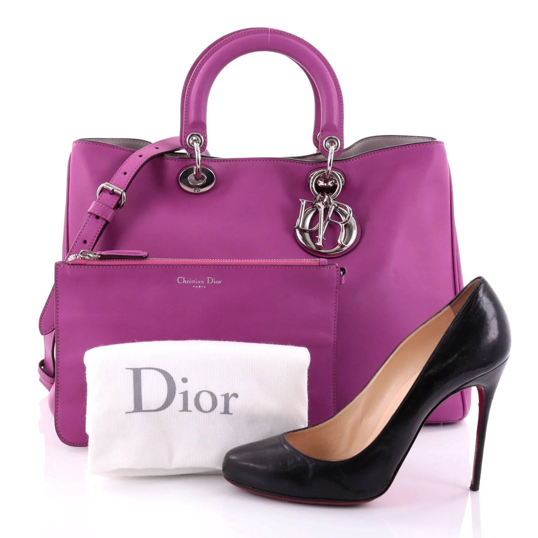 This authentic Christian Dior Diorissimo Tote Smooth Calfskin Large is an elegant, classic statement piece that every fashionista needs in her wardrobe. Crafted from bright purple leather, this chic tote features smooth short dual handles with sleek