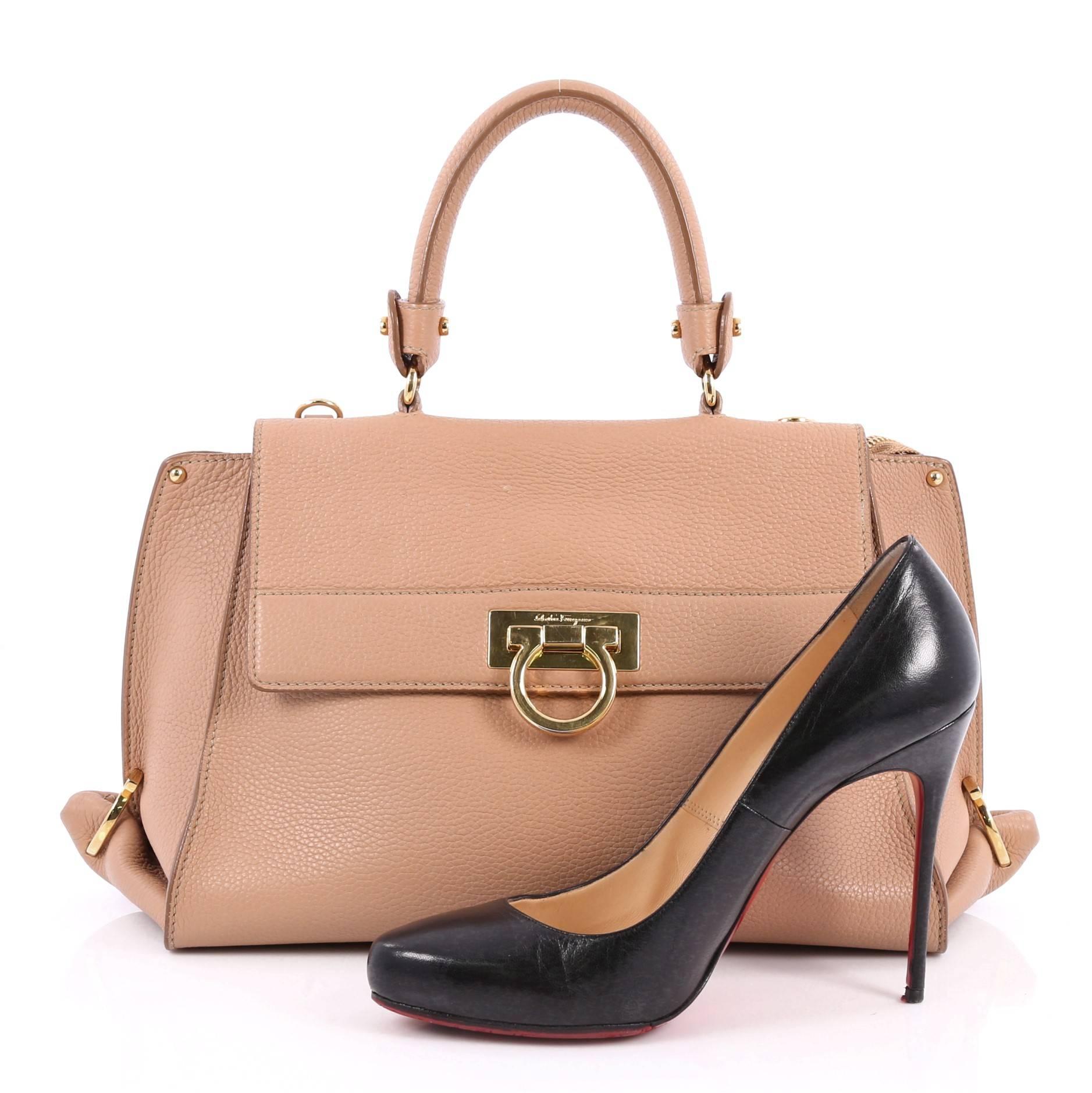 This authentic Salvatore Ferragamo Sofia Satchel Pebbled Leather Medium is a stylish and functional bag perfect for the modern woman. Crafted in nude pebbled leather, this bag features rolled leather handle, protective base studs, exterior back zip