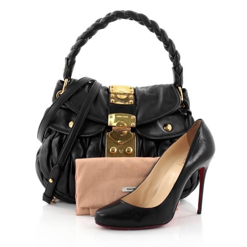 This authentic Miu Miu Coffer Convertible Hobo Matelasse Leather has a feminine ruched design that is unique to the brand. Crafted in black matelasse leather, this beautiful bag features a braided top handle, two exterior front flap pockets, and