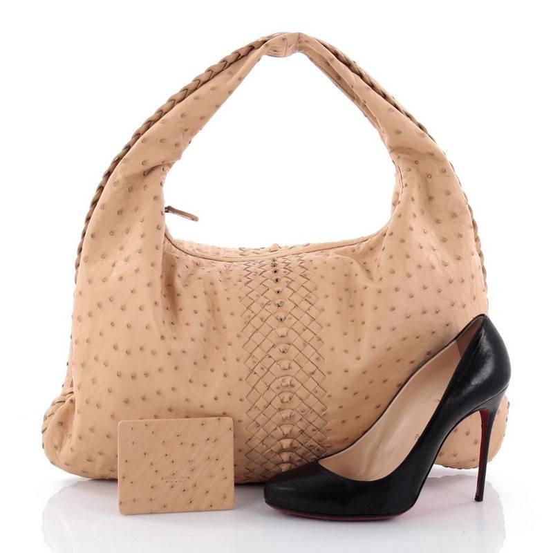 This authentic Bottega Veneta Veneta Hobo Ostrich Large is a timelessly elegant bag with a casual silhouette. Excellently crafted from genuine beige ostrich leather, this no-fuss hobo features a single looped strap and bronze-tone hardware accents.