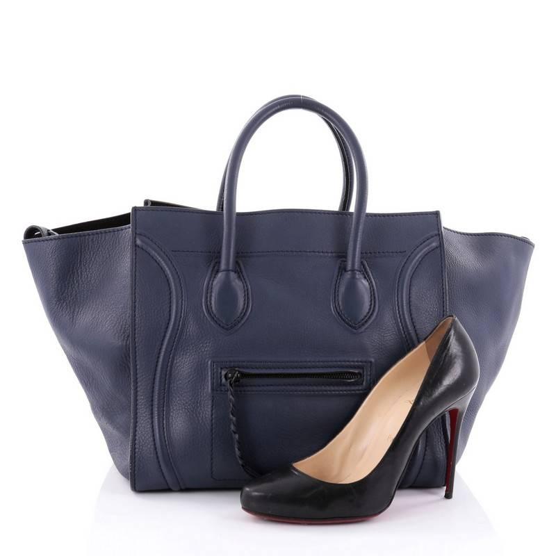 This authentic Celine Phantom Handbag Grainy Leather Medium is one of the most sought-after bags beloved by fashionistas. Crafted from navy leather, this minimalist tote features dual-rolled handles, an exterior front pocket, protective base studs,