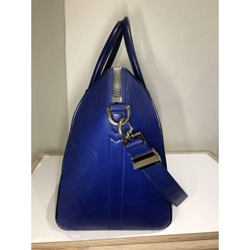 This authentic Givenchy Antigona Bag 3D Embossed Leather Medium is a go-to fashion favorite. Crafted from dark blue leather, this structured yet stylish tote features the brand's signature envelope flap detail with Givenchy logo, dual-rolled leather