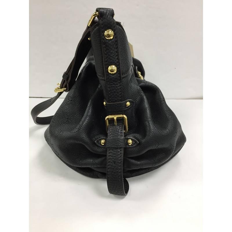 This authentic Louis Vuitton XS Crossbody Bag Mahina Leather is both stylish and functional. Crafted from black monogram perforated mahina leather, this shoulder bag features an adjustable leather strap, protective base studs, top belted strap with