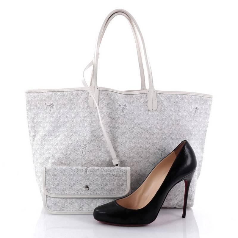 This authentic Goyard St. Louis Tote Coated Canvas PM is an ideal bag for everyday excursions. Crafted from the popular and traditional grey and white Goyard chevron coated canvas, this spacious tote features long, thin leather top handles, white