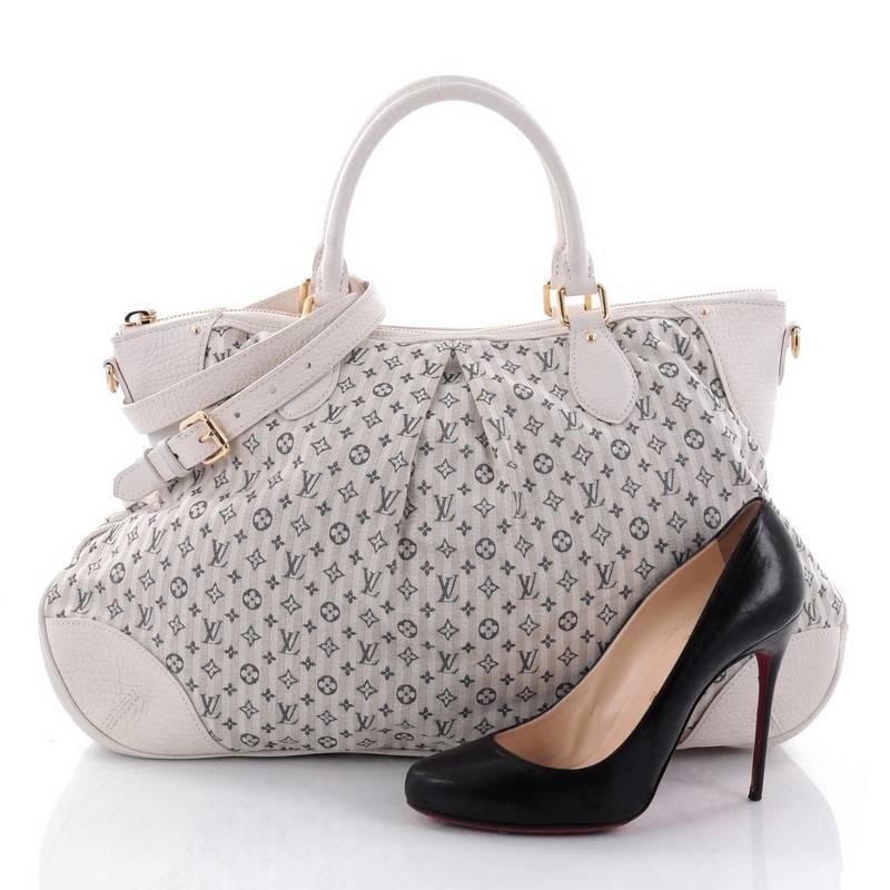 This authentic Louis Vuitton Marina Handbag Mini Lin Croisette GM in perfect for the on-the-go fashionista. Crafted from gray and white striped mini lin monogram canvas with leather trims, this feminine pleated satchel features dual-rolled handles