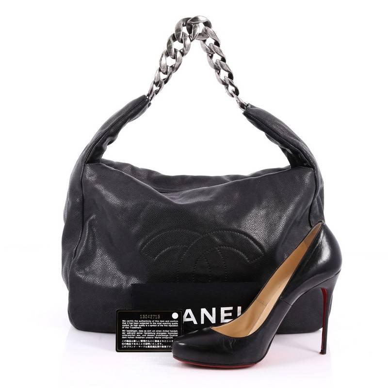 This authentic Chanel Caviar 31 Hobo Caviar, in a timeless and classic design, is perfect for the modern woman. Crafted in black caviar leather, this chic hobo features an oversized CC logo stitched at the front, gigantic silver textured chain links