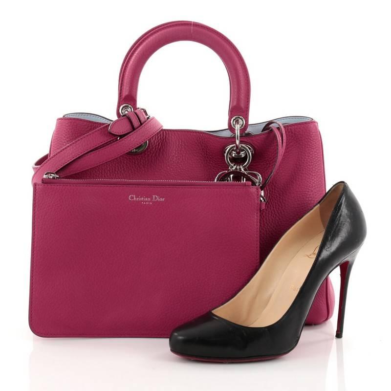 This authentic Christian Dior Diorissimo Tote Pebbled Leather Medium is an elegant, classic statement piece that every fashionista needs in her wardrobe. Crafted from fuchsia pebbled leather, this chic tote features smooth short dual handles with