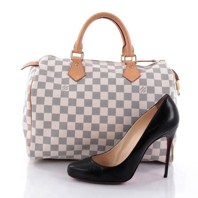 This authentic Louis Vuitton Speedy Handbag Damier 30 is a timeless favourite of many. Constructed from Louis Vuitton's signature damier azur coated canvas, this iconic Speedy features dual-rolled handles, vachetta leather trims and gold-tone