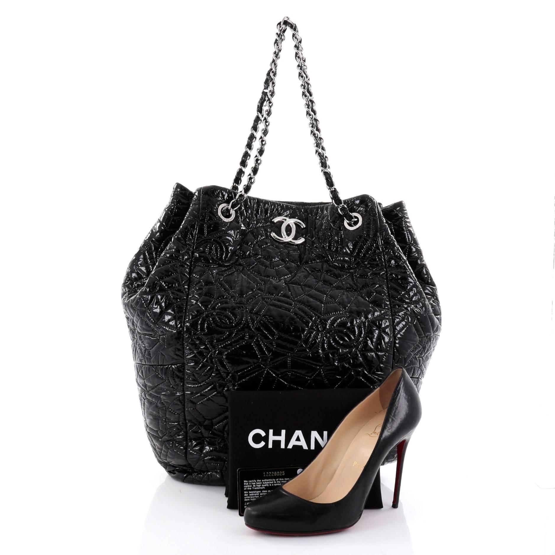 This authentic Chanel Graphic Edge Tote Patent Vinyl North South is an utterly chic and fabulous bag perfect for the modern fashionista. Crafted from black patent vinyl with quilted CC logos and geometric patterns, this stylish bag features dual