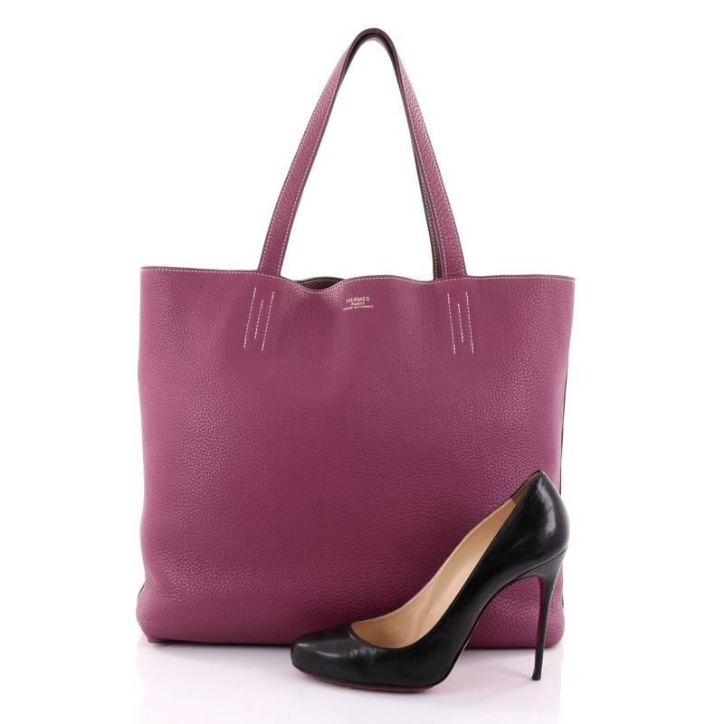 This authentic Hermes Double Sens Tote Clemence 45 combines a simple and functional style from Hermes perfect for everyday use. Crafted from soft luxurious reversible veau taurillon clemence leather in tosca purple and marron d'inde brown, this