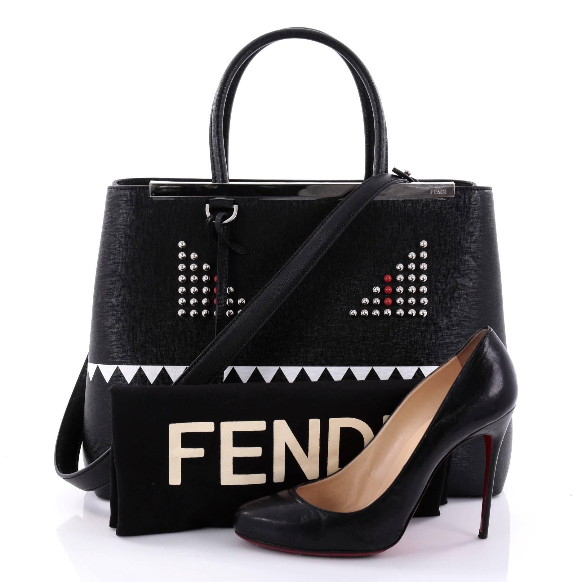 This authentic Fendi 2Jours Monster Handbag Leather Medium is a popular design that is impeccably stylish with its simple silhouette. Crafted from black leather, this structured tote features dual-rolled leather handles, a shining top bar with Fendi