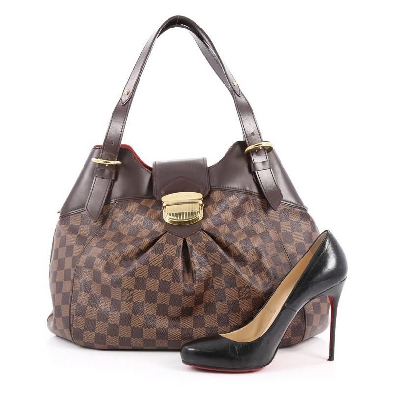 This authentic Louis Vuitton Sistina Handbag Damier GM is perfect for an everyday look for the modern woman. Crafted in the brand's iconic damier ebene coated canvas, this stylish yet feminine tote features subtle center pleating, smooth brown