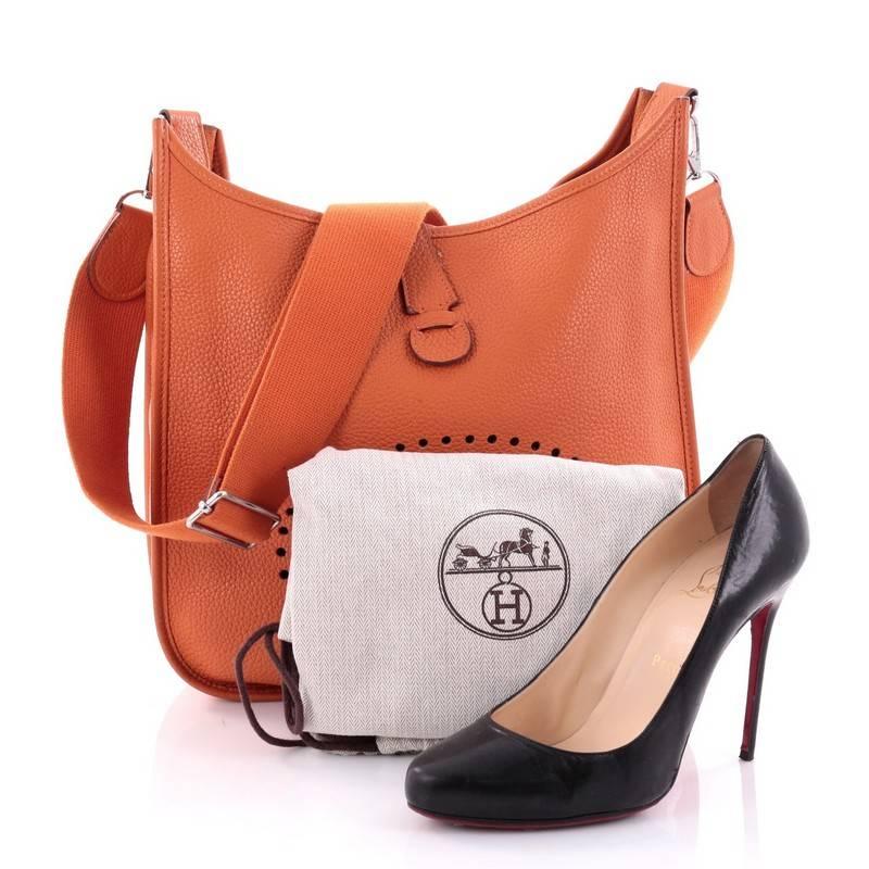 This authentic Hermes Evelyne Crossbody Gen III Togo PM showcases a simple, day-to-day style perfect for someone's first Hermes bag. Crafted from orange togo leather, this crossbody bag features a signature perforated H design at the front,