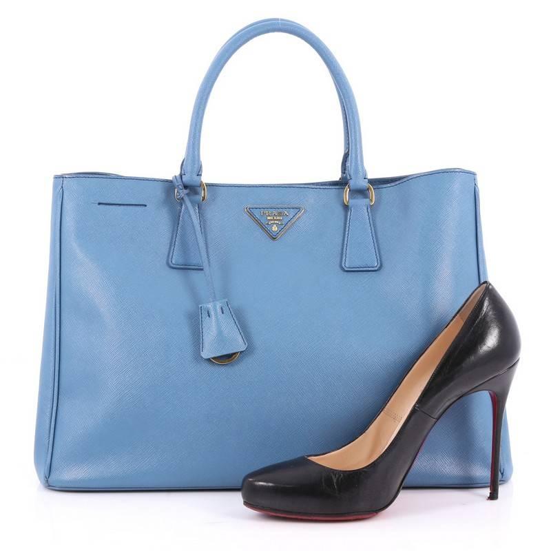 This authentic Prada Lux Open Tote Saffiano Leather Large is elegant in its simplicity and structure. Crafted from blue saffiano leather, this sturdy and spacious tote features dual-rolled handles, gusseted side with snap buttons, iconic inverted