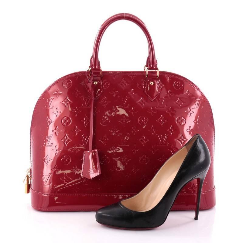 This authentic Louis Vuitton Alma Handbag Monogram Vernis GM is a fresh and elegant spin on a classic style that is perfect for all seasons. Crafted from Louis Vuitton's red monogram vernis leather, this dome-shaped satchel features dual-rolled