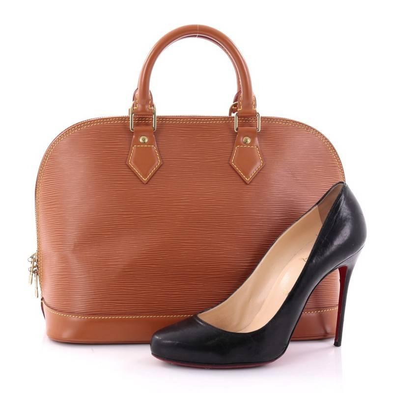 This authentic Louis Vuitton Vintage Alma Handbag Epi Leather PM is elegant and as classic as they come. Constructed with Louis Vuitton's signature sturdy brown epi leather, this iconic bag features dual rolled handles, a sturdy reinforced base,