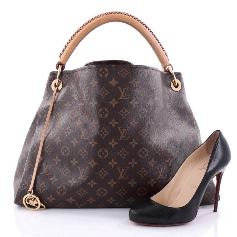 This authentic Louis Vuitton Artsy Handbag Monogram Canvas MM is an elegant and iconic bag that adds a stylish flair to any outfit. Crafted from Louis Vuitton's iconic brown monogram coated canvas, this roomy Artsy hobo features rolled leather
