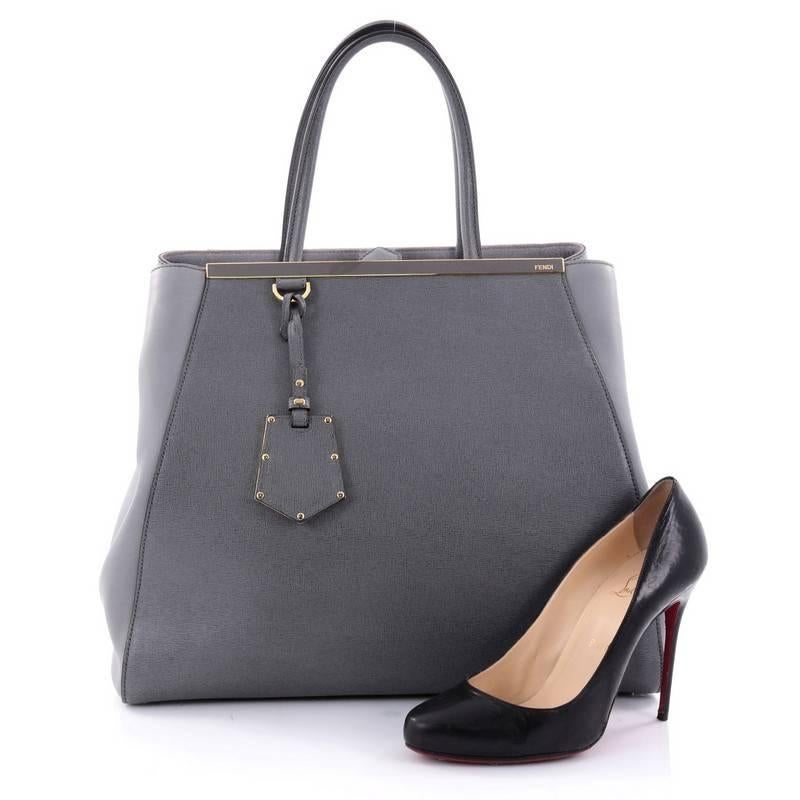 This authentic Fendi 2Jours Handbag Leather Large is an impeccably stylish bag perfect for your everyday looks. Crafted in grey leather with smooth side wings, this popular tote features dual-rolled leather handles, accented with a shining top bar