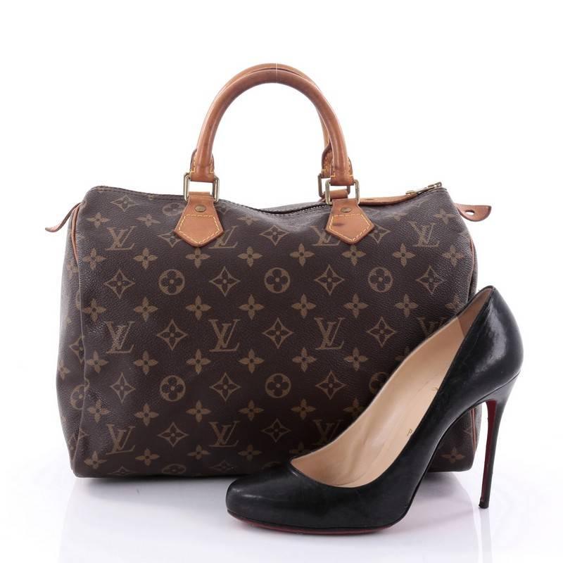 This authentic Louis Vuitton Speedy Handbag Monogram Canvas 30 is spacious and light, making it ideal to use everyday. Constructed in Louis Vuitton's classic brown monogram coated canvas, this iconic Speedy features dual-rolled leather handle,