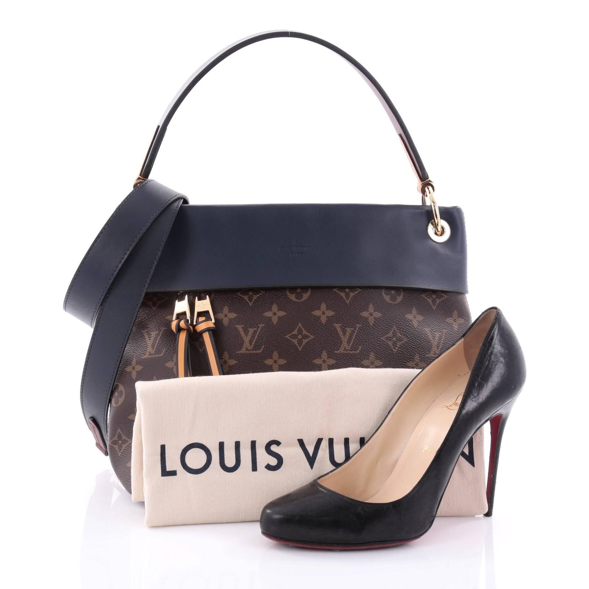 This authentic Louis Vuitton Tuileries Besace Bag Monogram Canvas with Leather was inspired by the Tuileries Gardens in Paris. Crafted from brown monogram coated canvas, this ultra functional bag features navy blue leather trims, flat leather