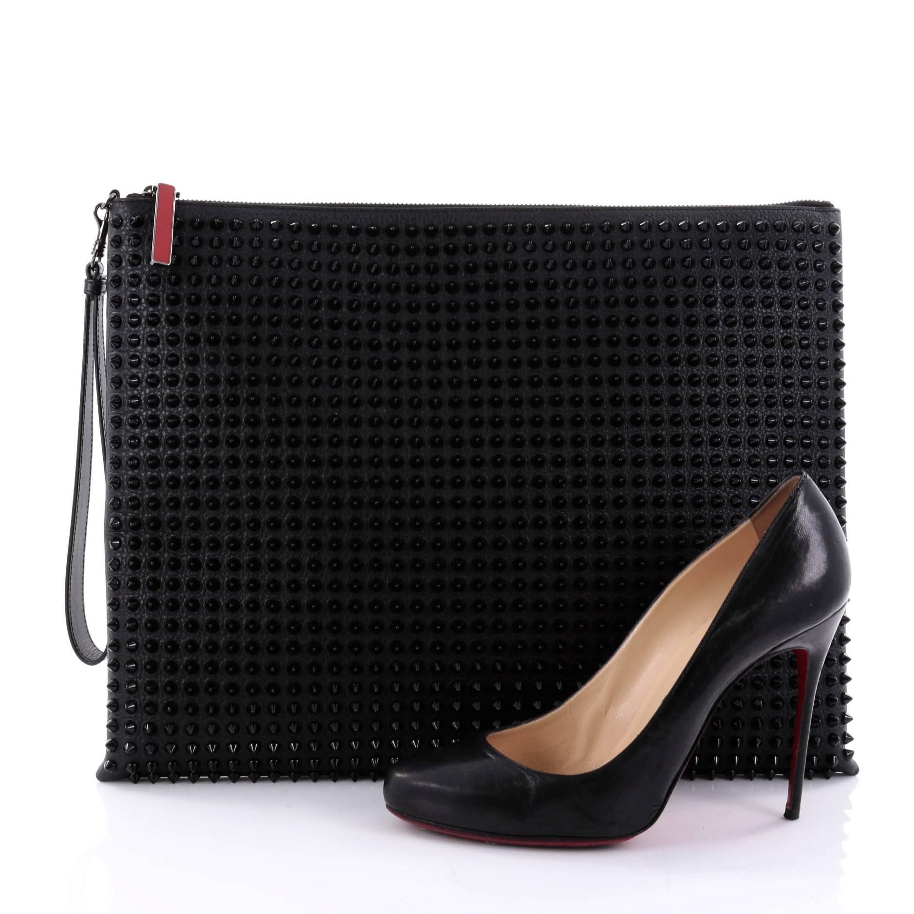 This authentic Christian Louboutin Peter Pouch Spiked Leather Medium is a multifunctional pouch perfect for chic fashionista on the go. Crafted in black spiked leather, this chic pouch features a wristlet strap, exterior back zip pocket, and aged