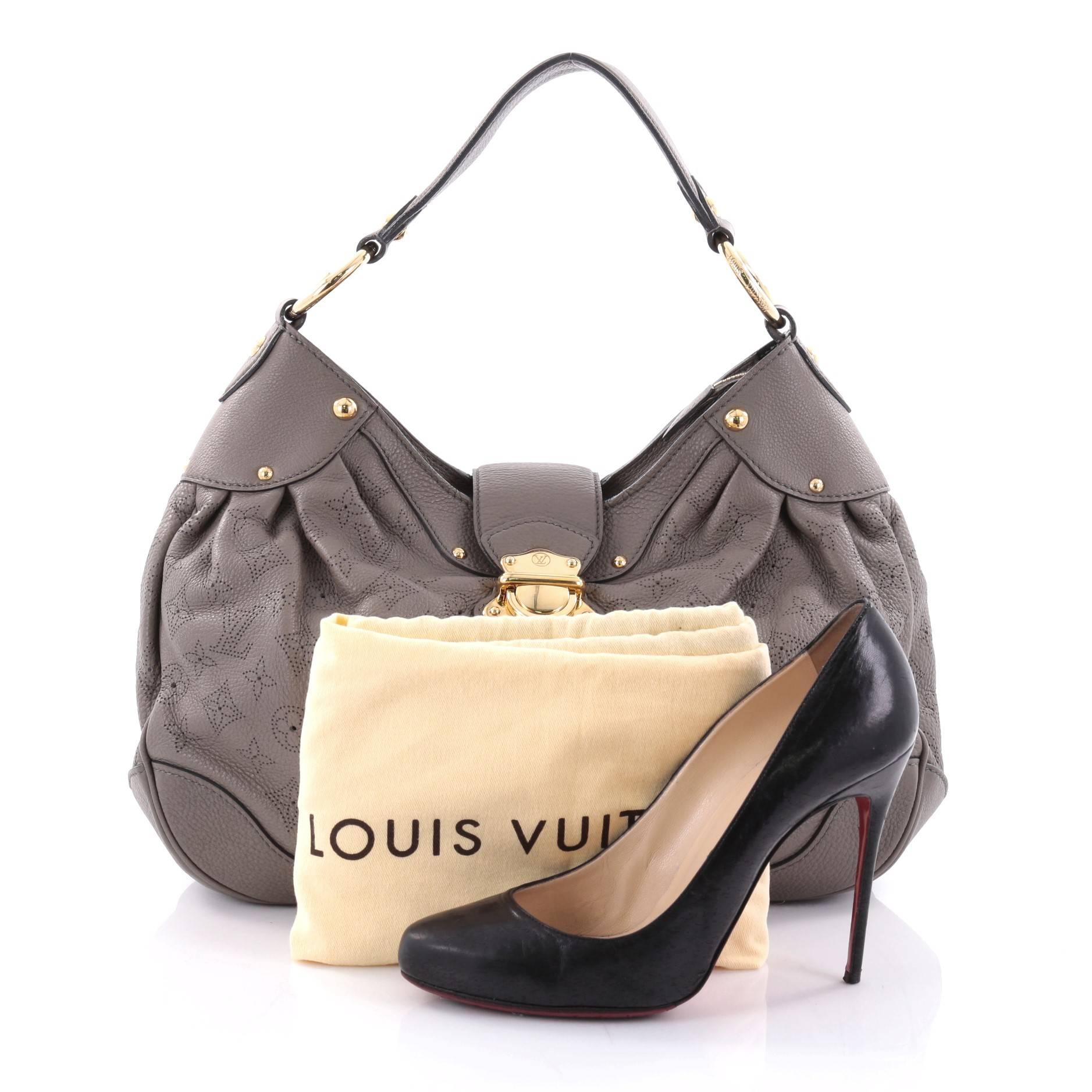 This authentic Louis Vuitton Solar Handbag Mahina Leather PM is an easy, feminine design constructed with intricate gray perforated monogram mahina leather. Showcased in the brand's Spring/ Summer 2010 Collection, this roomy hobo features a