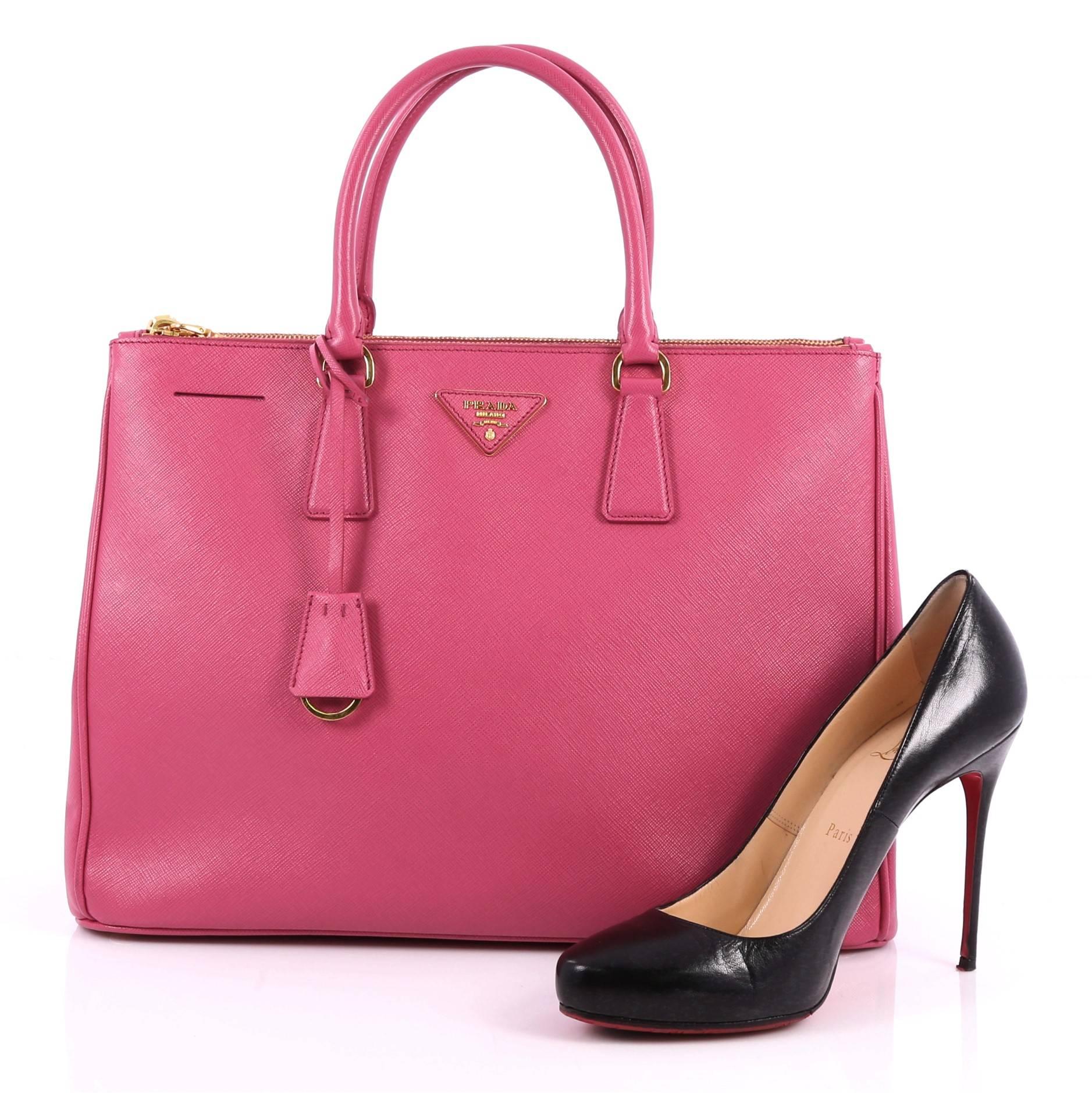 This authentic Prada Double Zip Lux Tote Saffiano Leather Large is the perfect bag to complete any outfit. Crafted from pink saffiano leather, this boxy tote features side snap buttons, raised Prada logo, dual-rolled leather handles and gold-tone