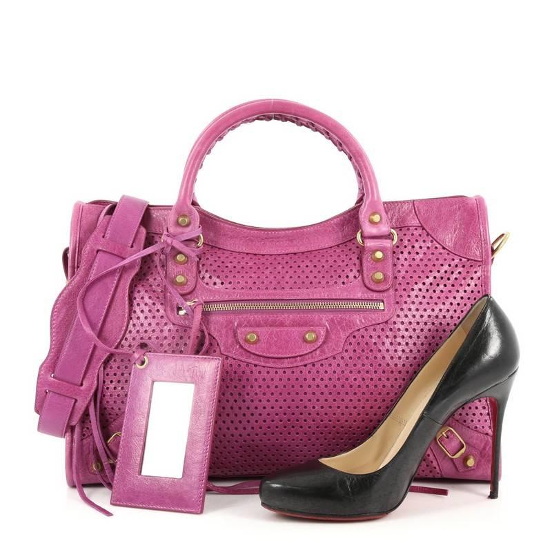 This authentic Balenciaga City Classic Studs Handbag Perforated Leather Medium is for the on-the-go fashionista. Constructed in purple perforated leather, this bag features braided woven handles, long fringe details, iconic Balenciaga classic