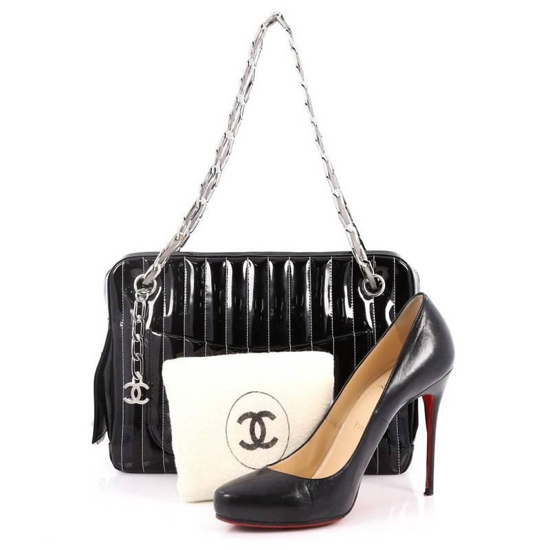 This authentic Chanel Mademoiselle Camera Bag Vertical Quilted Patent Medium is a gorgeous and extremely rare bag that's a modern twist to the classic camera bag. Crafted in black vertical quilted patent leather, this stylish bag features dual