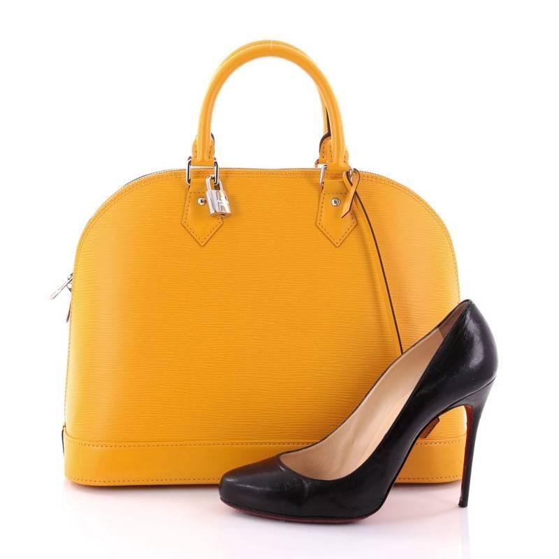 This authentic Louis Vuitton Alma Handbag Epi Leather MM is a chic and sophisticated bag perfect for your everyday use. Constructed with yellow epi leather, this dome-like bag features a sturdy base, protective base studs, dual-rolled handles,