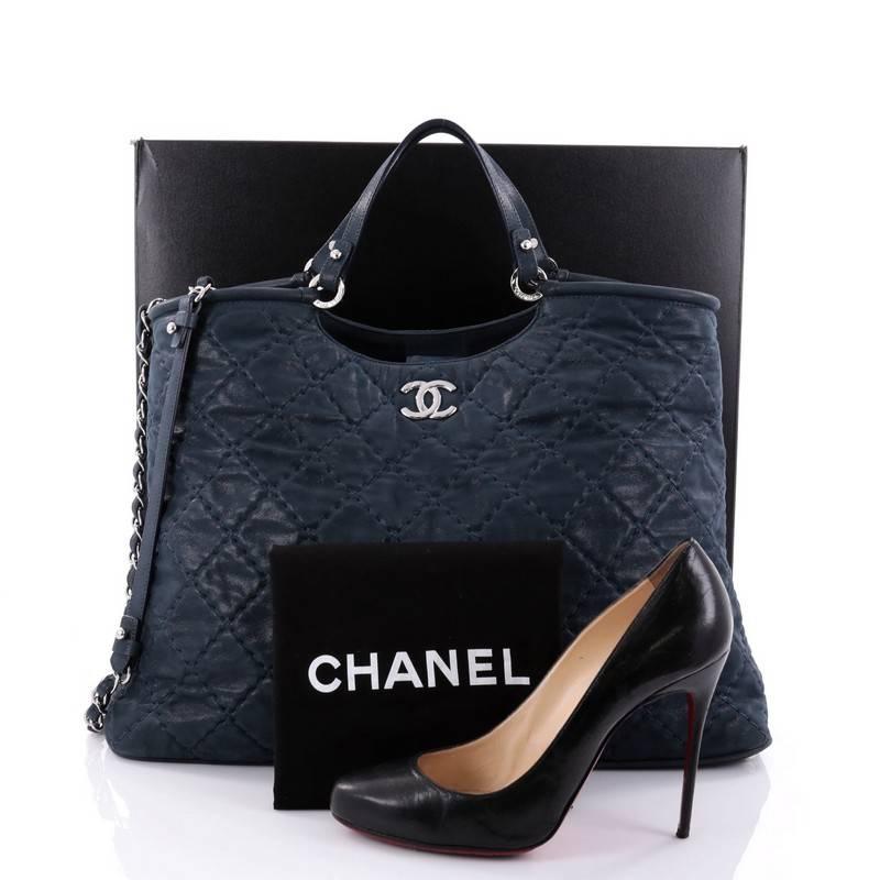 This authentic Chanel CC Sea Hit Tote Quilted Iridescent Calfskin Large is a stylish tote and an ideal everyday bag with room for all of your necessities. Crafted from navy quilted iridescent calfskin leather, this timeless bag features leather