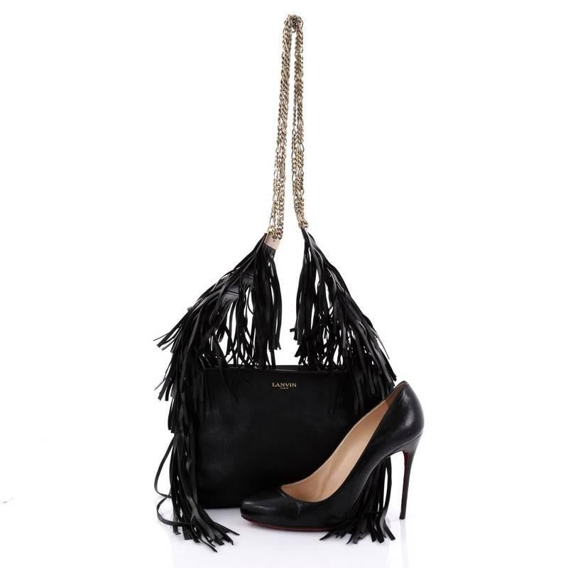 This authentic Lanvin Tribale Shoulder Bag Leather mixes an edgy, boho chic design made for daring fashionistas. Crafted in black leather, this shoulder bag features gold chain straps, cascading leather fringes, stamped Lanvin logo and gold-tone