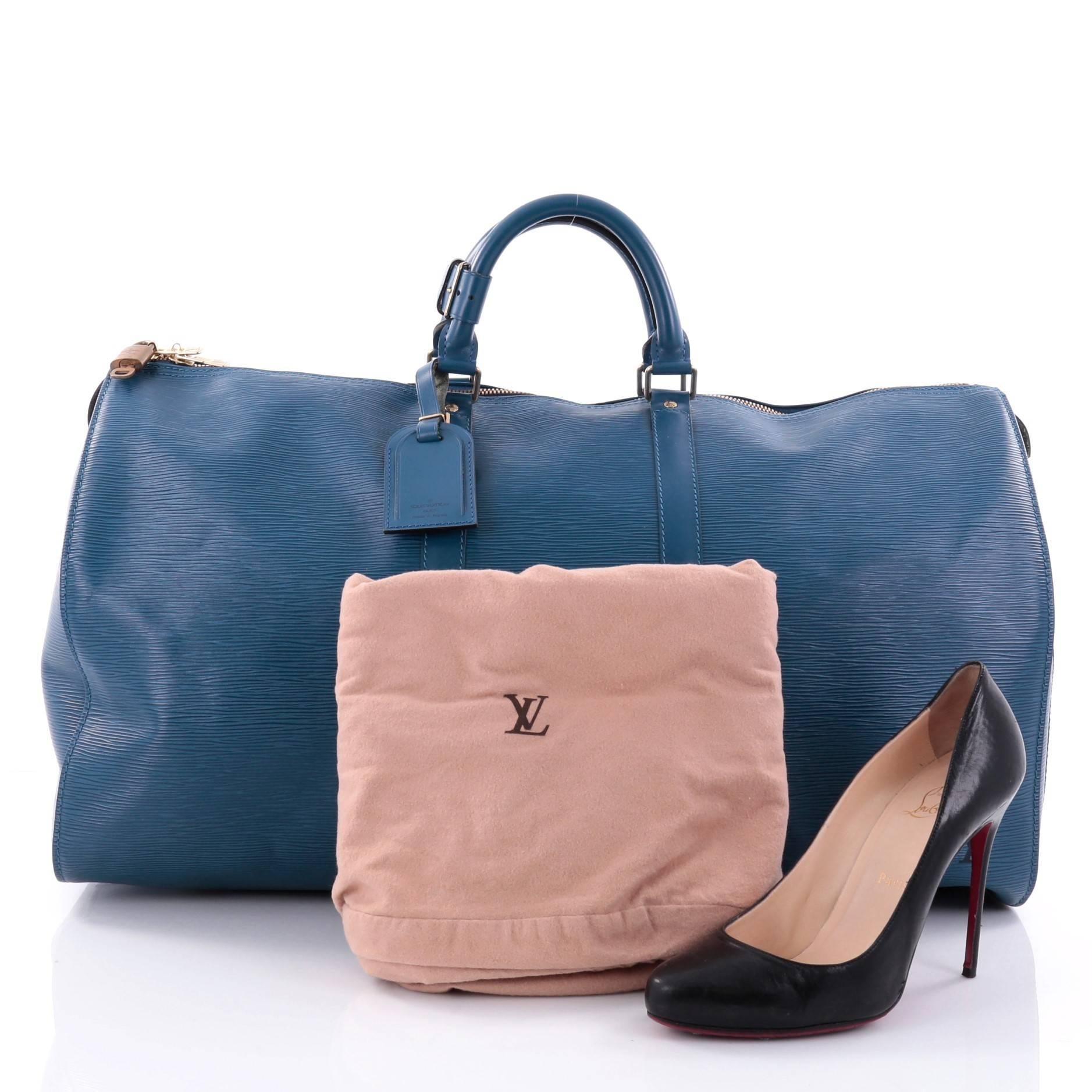 This authentic Louis Vuitton Keepall Bag Epi Leather 55 features the brand's timeless travel bags. Constructed from sleek blue epi leather, this iconic Keepall as classic as the Speedy features dual-rolled handles, subtle LV logo and gold-tone