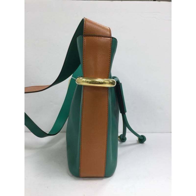 This authentic Chloe Emma Bucket Bag Leather Small mixes elegant style and sophistication made for daily needs. Crafted from green leather with brown leather trims, this luxurious bucket bag features a flat shoulder strap, drawstring top with metal