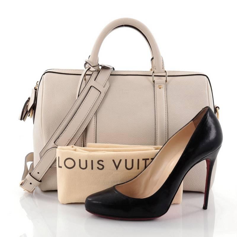 This authentic Louis Vuitton Sofia Coppola SC Bag Leather PM is a stylish and elegant everyday bag. Crafted from off-white leather, this simple yet refined duffle bag features sturdy rolled handles, adjustable shoulder strap, protective base studs