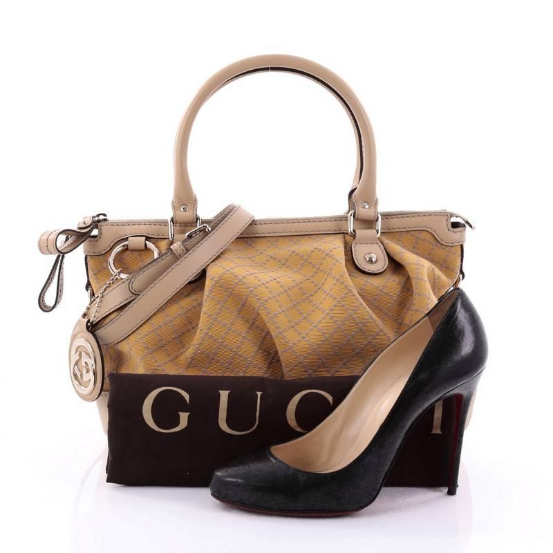 This authentic Gucci Sukey Top Handle Satchel Diamante Canvas Medium is a chic tote ideal for your everyday wear. Crafted from yellow diamante canvas with beige leather trims, this roomy tote features a ruched design, dual-rolled handles that sit