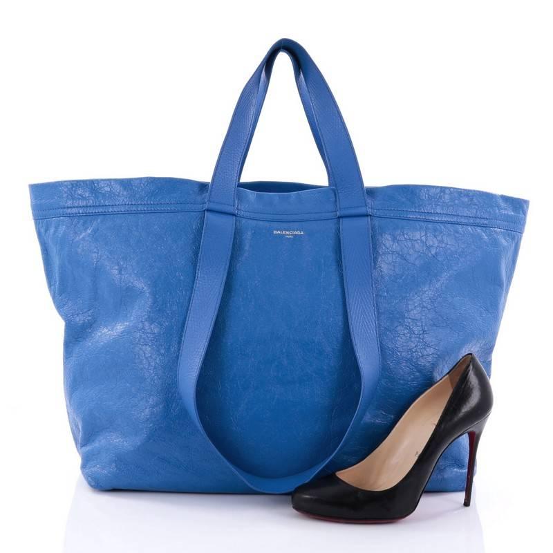 This authentic Balenciaga Carry Shopper Handbag Leather Large is a stylish and practical bag perfect for your everyday excursions. Crafted in blue leather, this shopper bag features dual flat leather handles (long and short), embossed Balenciaga