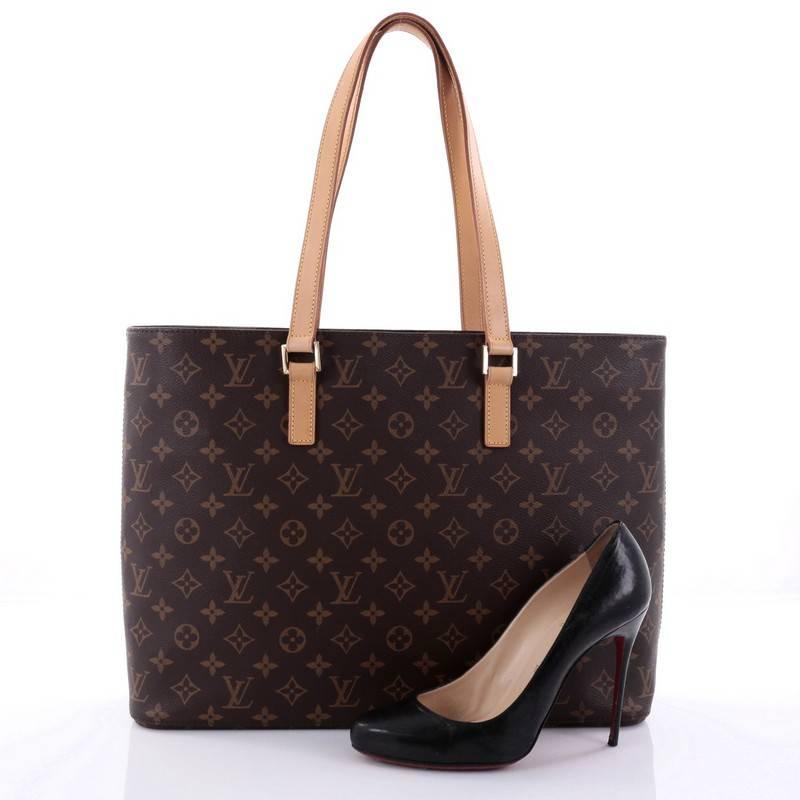 This authentic Louis Vuitton Luco Handbag Monogram Canvas is a classic tote that displays fashion and functionality all rolled into one. Crafted with the brand's iconic brown monogram coated canvas, this tote features dual flat leather handles, a