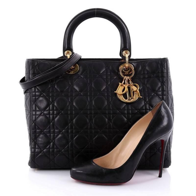 This authentic Christian Dior Lady Dior Handbag Cannage Quilt Lambskin Large is a classic staple that every fashionista needs in her wardrobe. Crafted from black lambskin leather in Dior's iconic cannage quilting, this boxy bag features dual-rolled