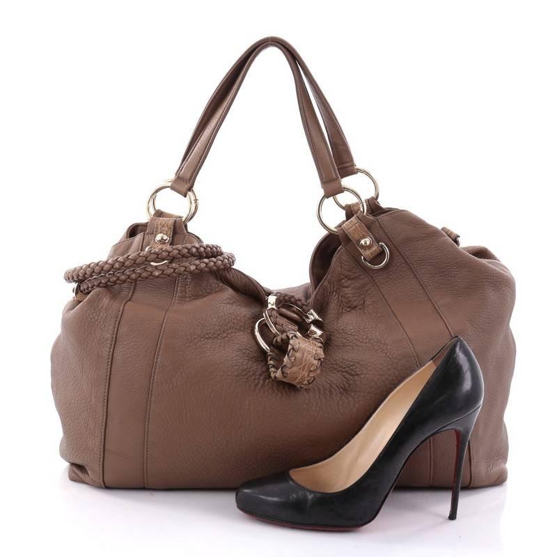 This authentic Gucci G Wave Tote Leather Large is a unique piece that will perfectly add to your collection. Crafted in brown leather, this tote features dual top leather handles, exotic crocodile belt tab, braided Gucci logo, and gold-tone hardware