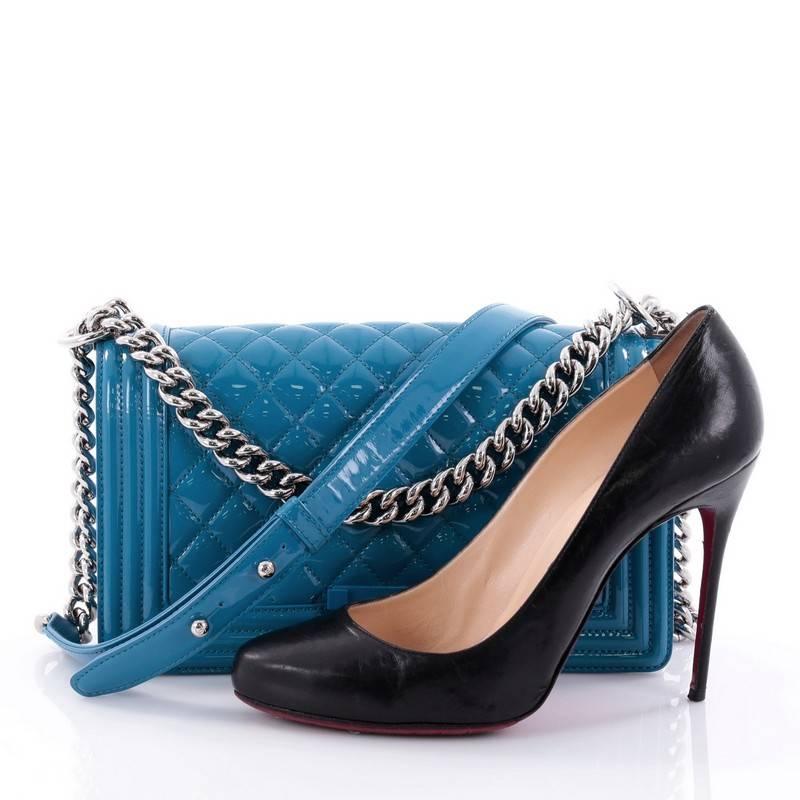 This authentic Chanel Boy Flap Bag Quilted Plexiglass Patent Old Medium is every woman's dream. Crafted from striking blue quilted patent leather, this enviable Boy flap bag features a chunky chain link strap with shoulder pad, frontal unique blue
